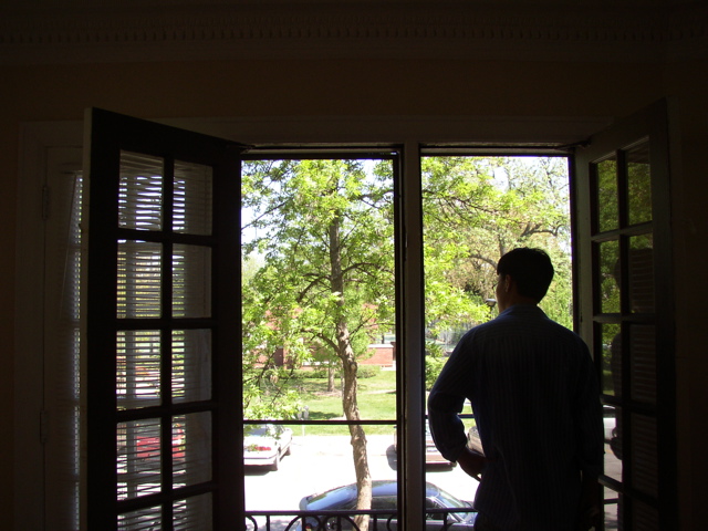 Brian standing in living room looking out at park